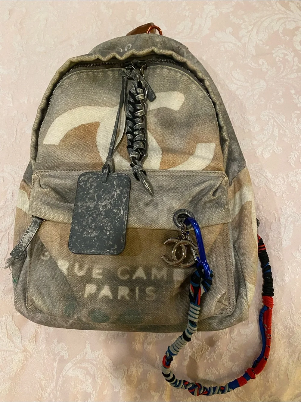 CHANEL Faded Beige Canvas Backpack with Multicolor Strap and Silver-Tone Charm